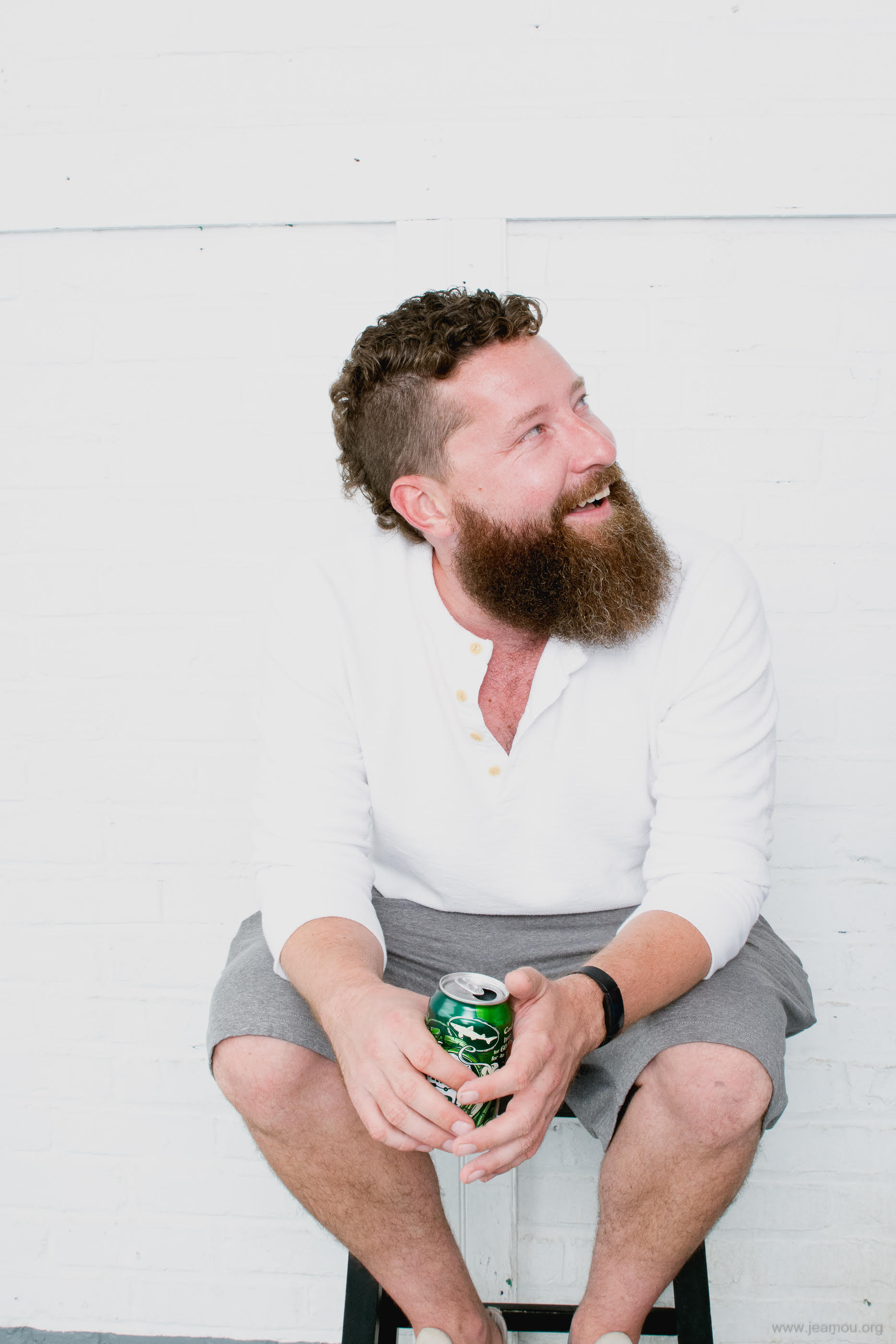 Cameron Chateauneuf, seated against a white brick wall